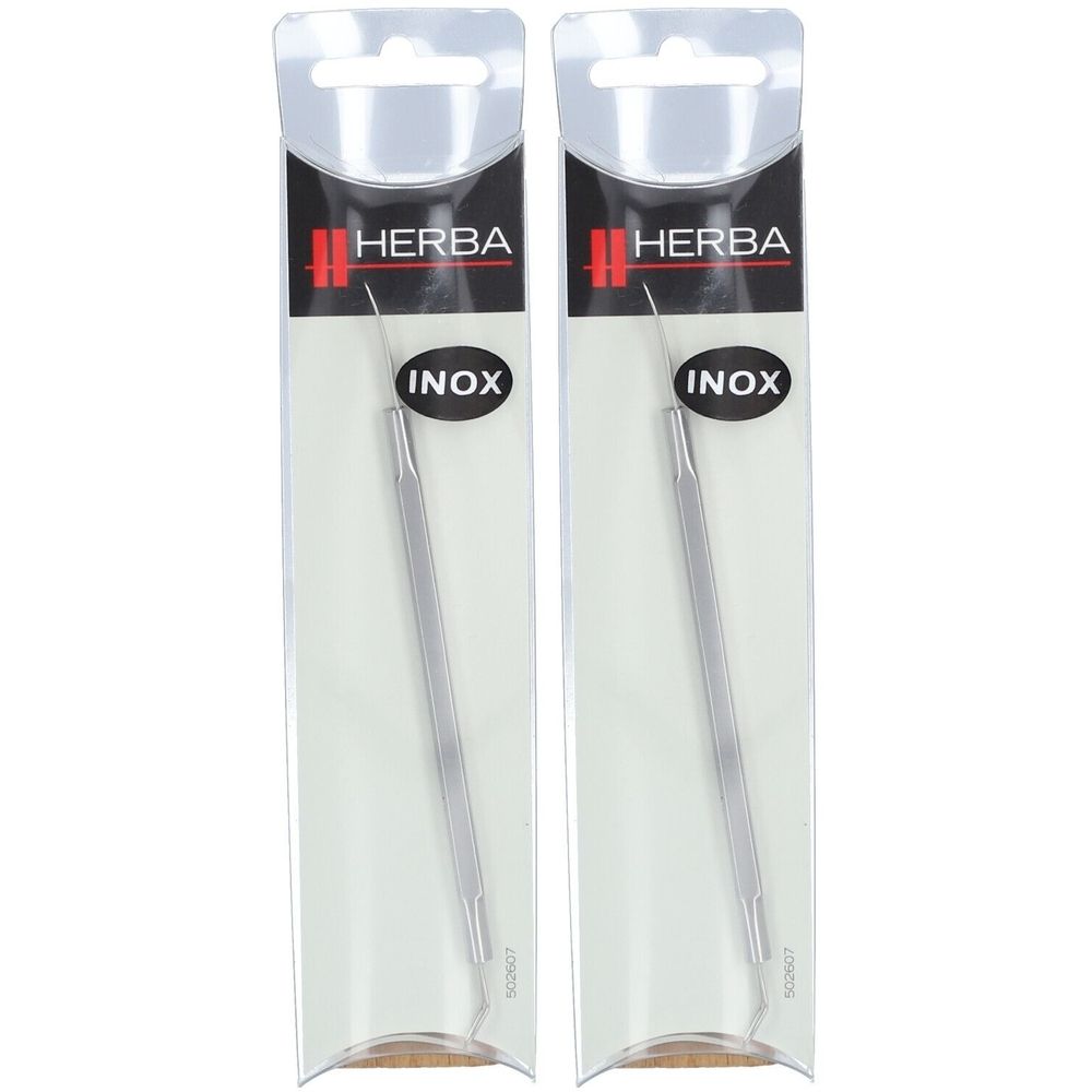 Zwei HERBA INOX Mitesserzieher in Blisterverpackung. Metallfarbenes Werkzeug mit spitzem und abgerundetem Ende.