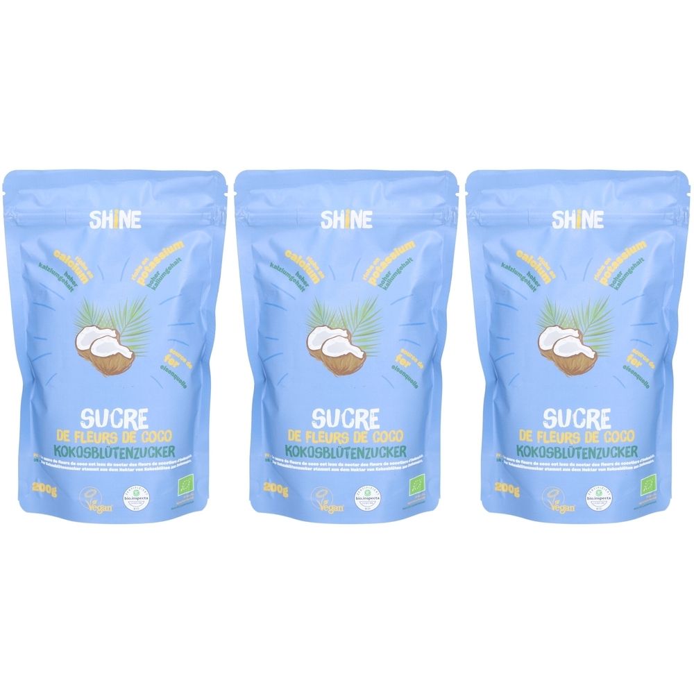 Drei blaue Beutel mit Kokosblütenzucker. Aufschrift: SHINE, SUCRE DE FLEURS DE COCO, KOKOSBLUTENZUCKER. Bio-Siegel.