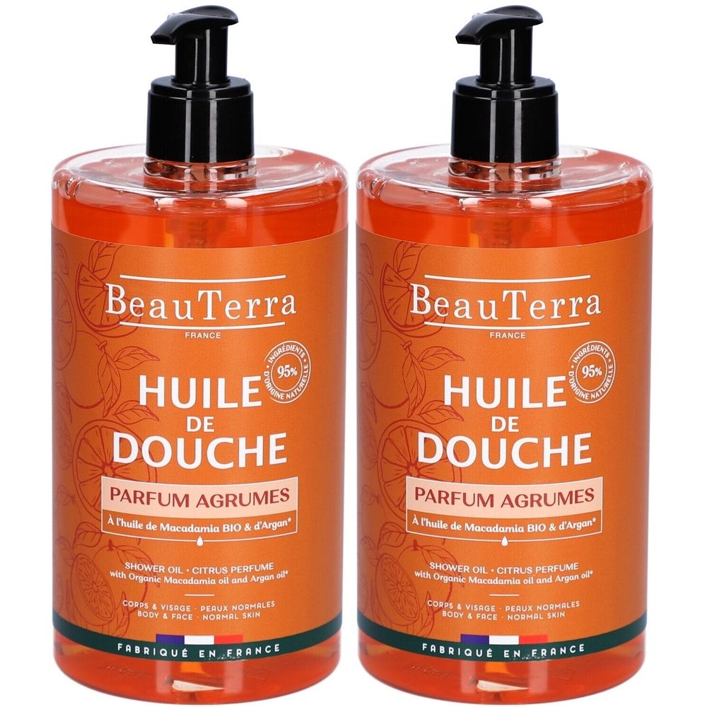 Deux flacons d'huile de douche avec pompes noires. Étiquettes orange avec nom du produit et inscription "Parfum Agrumes".