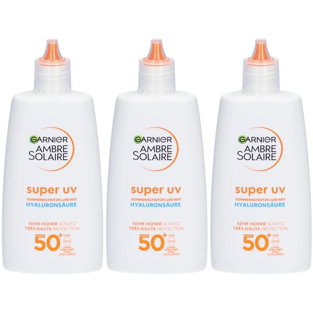Trois flacons blancs avec des embouts orange. Chaque flacon porte l'inscription "GARNIER AMBRE SOLAIRE super uv" et "50+".