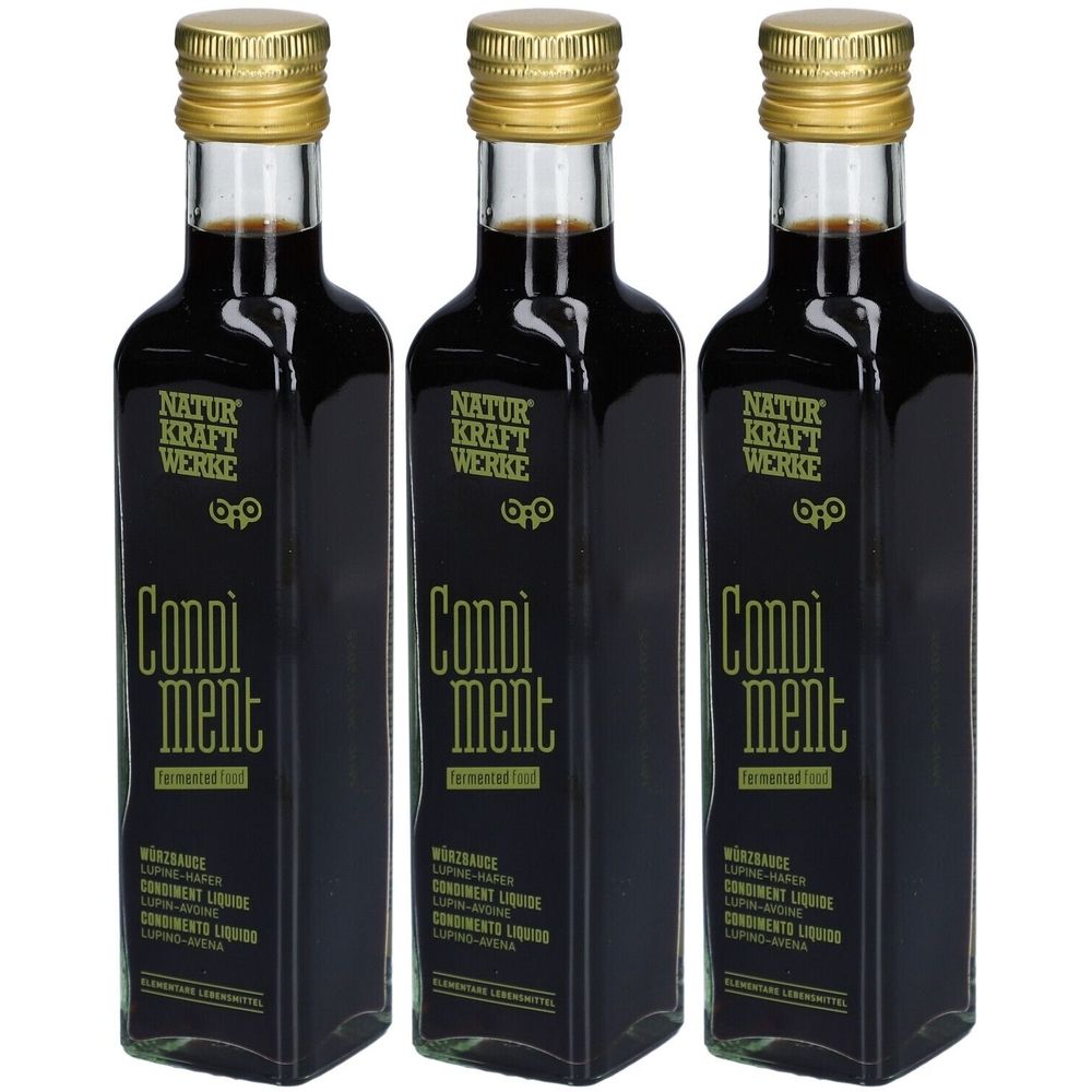Drei Flaschen mit goldfarbenen Deckeln. Aufschrift: NATUR KRAFT WERKE, Condiment. Schwarze Flüssigkeit. Etikett mit weiteren Informationen.
