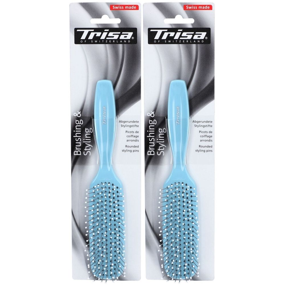 Deux brosses à cheveux bleues avec des picots blancs. Emballage avec logo et texte "Trisa".