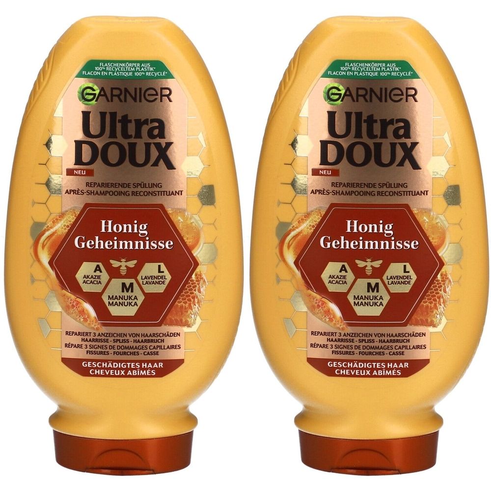 Zwei gelbe Flaschen mit braunen Deckeln. Aufschrift: GARNIER Ultra DOUX Honig Geheimnisse. Text in Deutsch und Französisch.