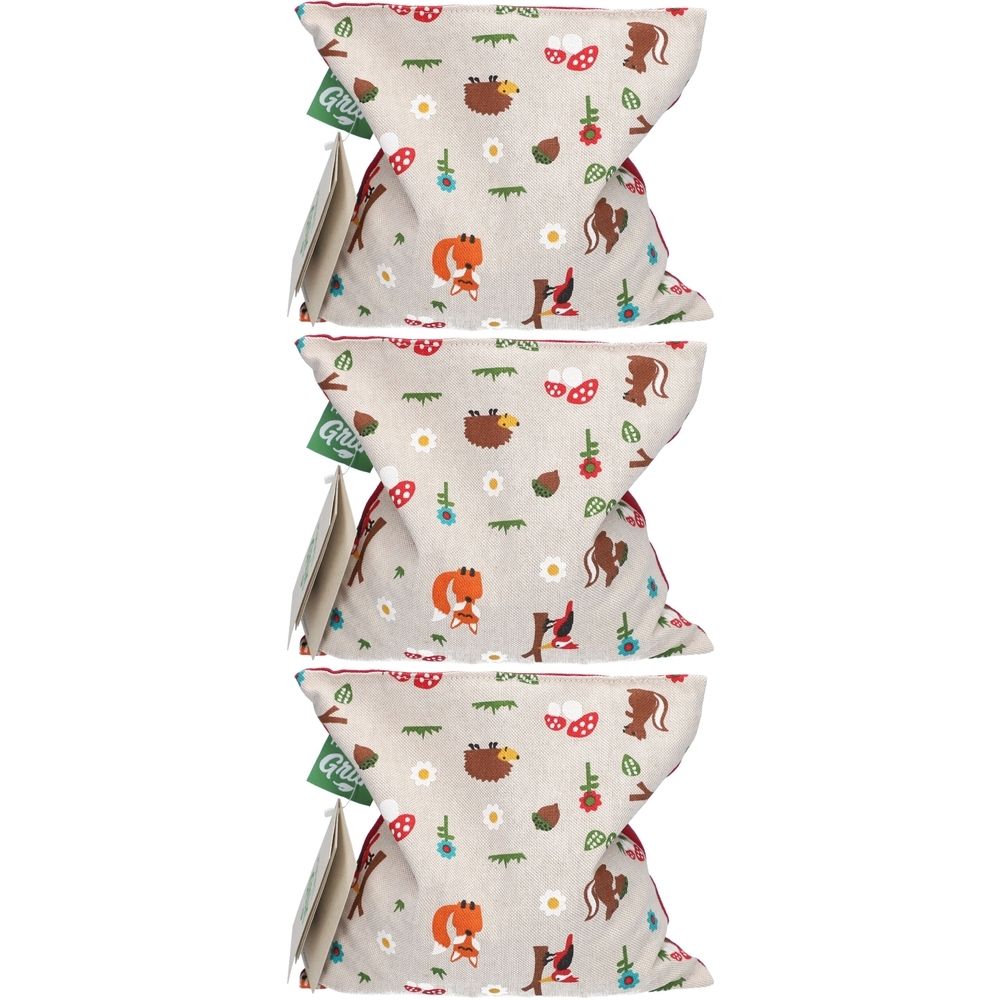 Drei Kirschkernkissen mit Waldtier-Design. Beige Stoff mit Fuchs, Igel, Pilz- und Blumenmuster. Grüne Anhänger mit Logo.