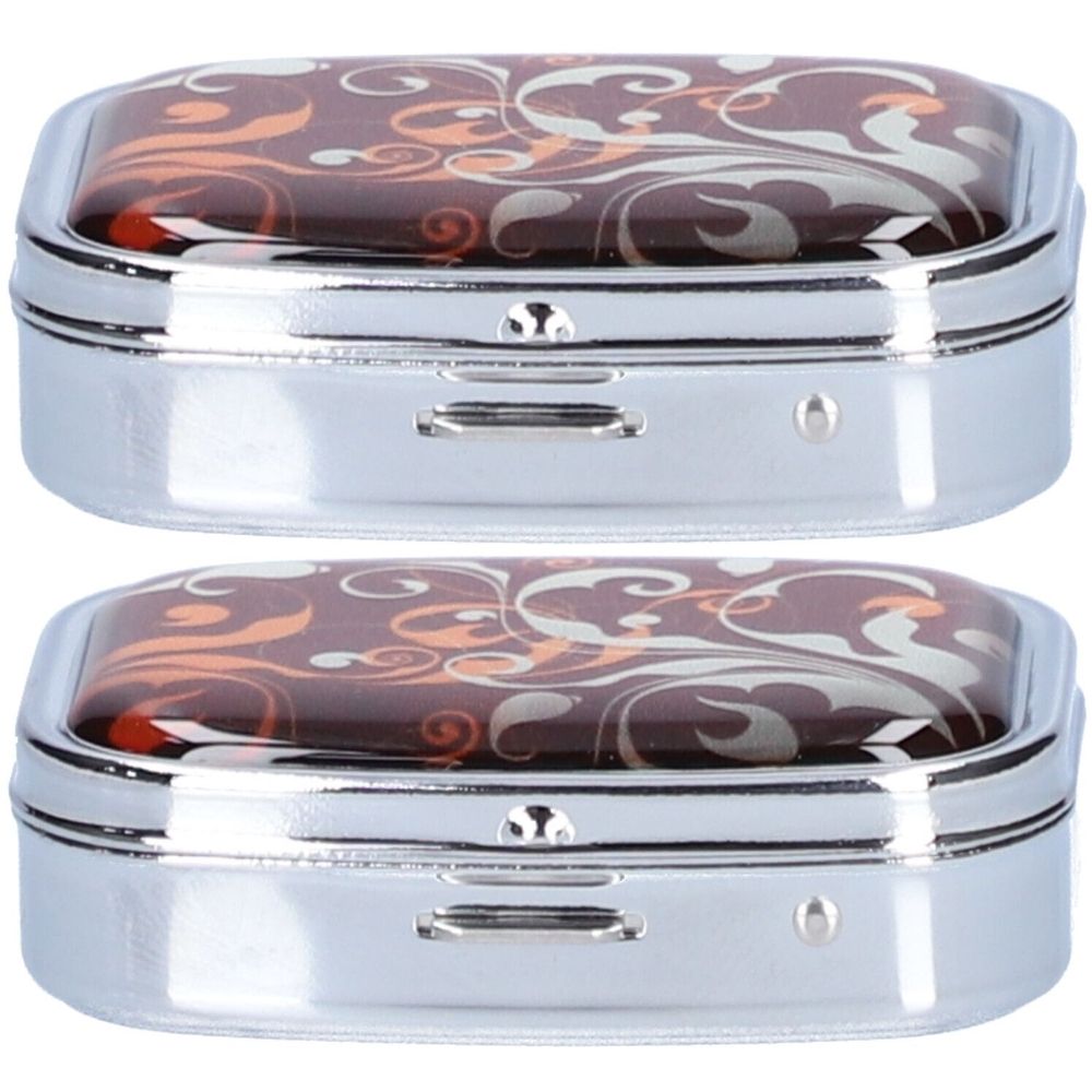 Zwei rechteckige Pillendosen mit floralem Muster auf dem Deckel. Metallrahmen, zwei Fächer. Farblich sortiert.