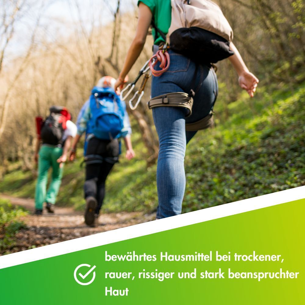 Wanderer auf einem Waldweg. Text: Bewährtes Hausmittel bei trockener, rauer, rissiger und stark beanspruchter Haut.