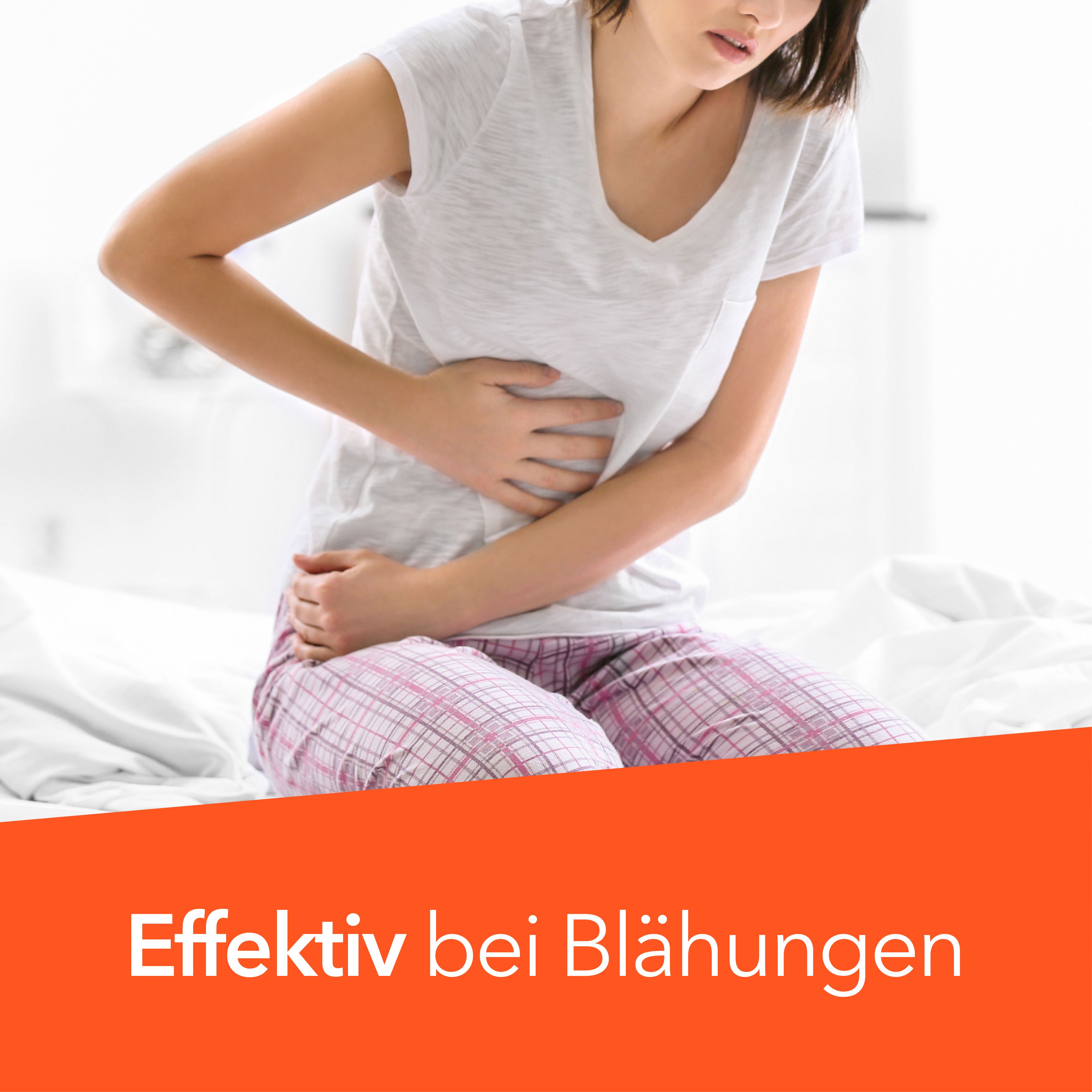 Femme assise sur un lit, se tenant le ventre. Bande orange avec texte : Effektiv bei Blähungen.
