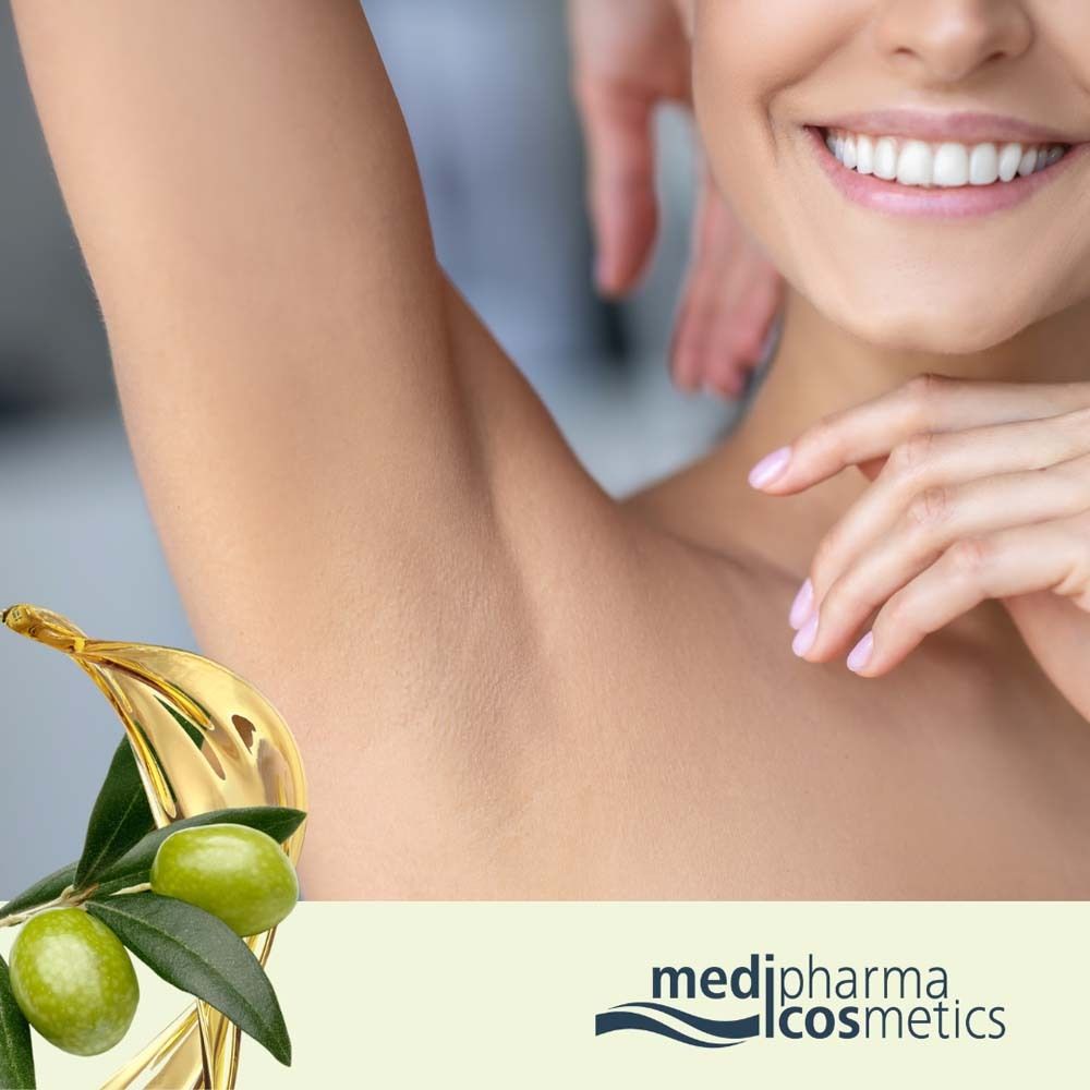 Gros plan d'une femme avec un bras. Branche d'olivier avec olives et huile d'olive. Marque: medipharma cosmetics.