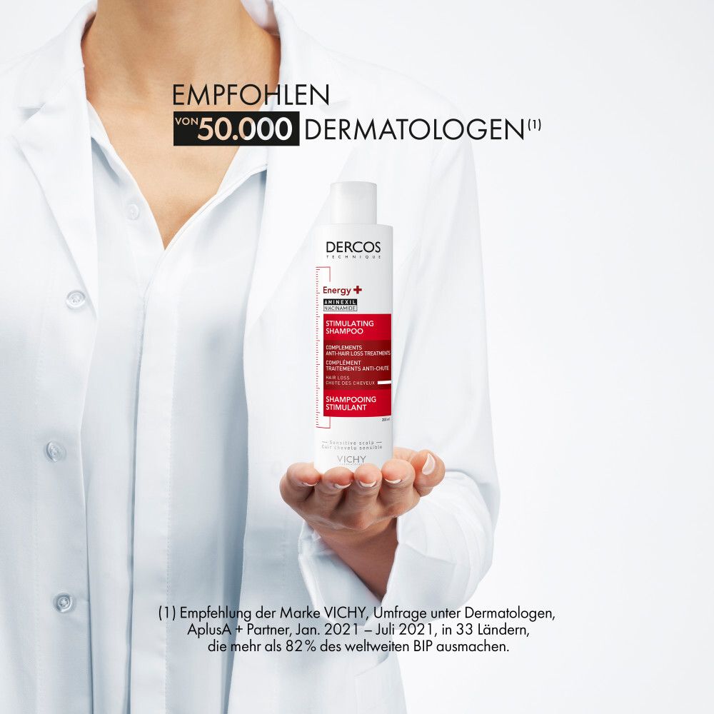 Personne tenant un shampooing. Texte: Recommandé par 50 000 dermatologues. VICHY Dercos. Blouse blanche.