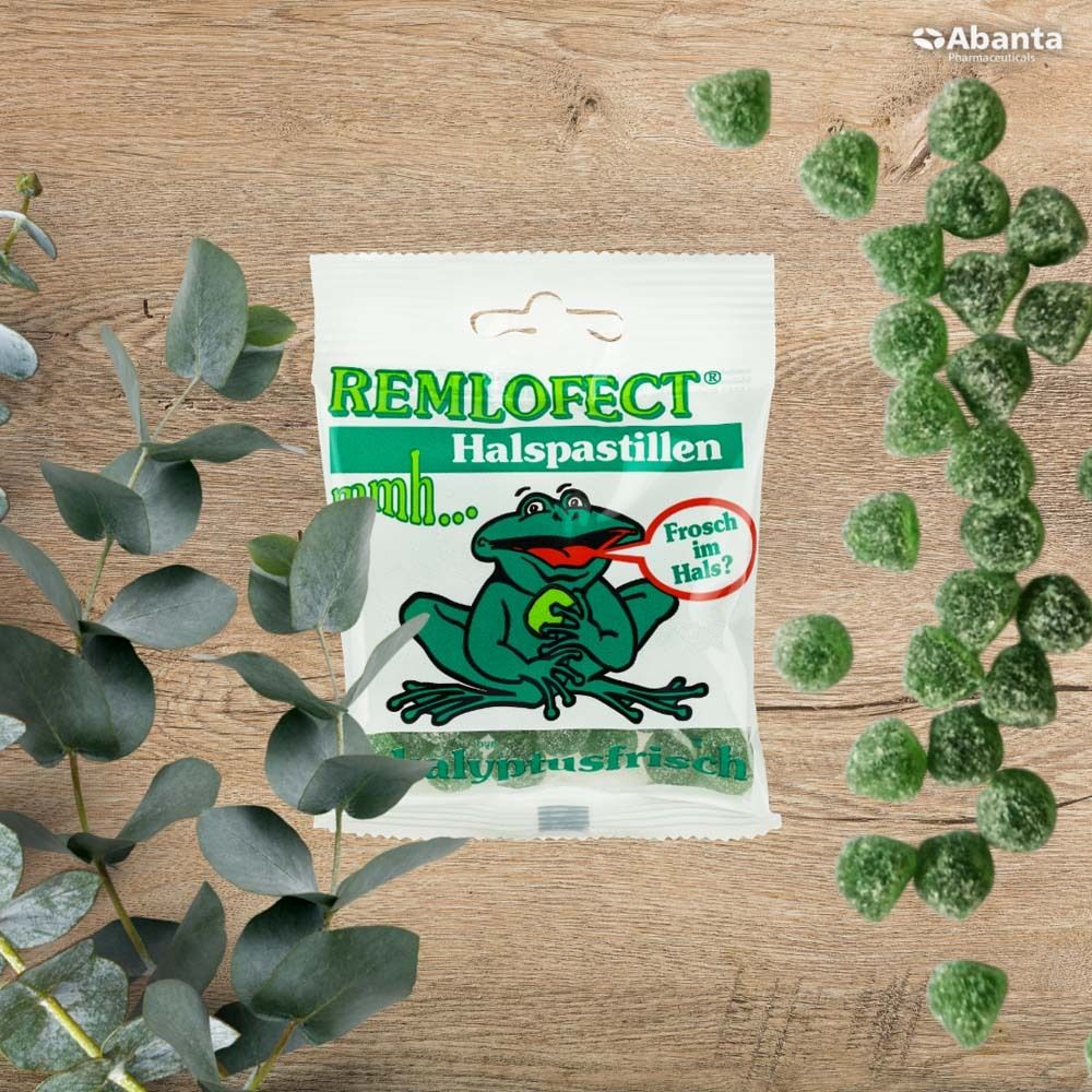 Paquet de pastilles pour la gorge REMLOFECT sur bois. Emballage vert et blanc avec illustration de grenouille. Texte : Eukalyptusfrisch.