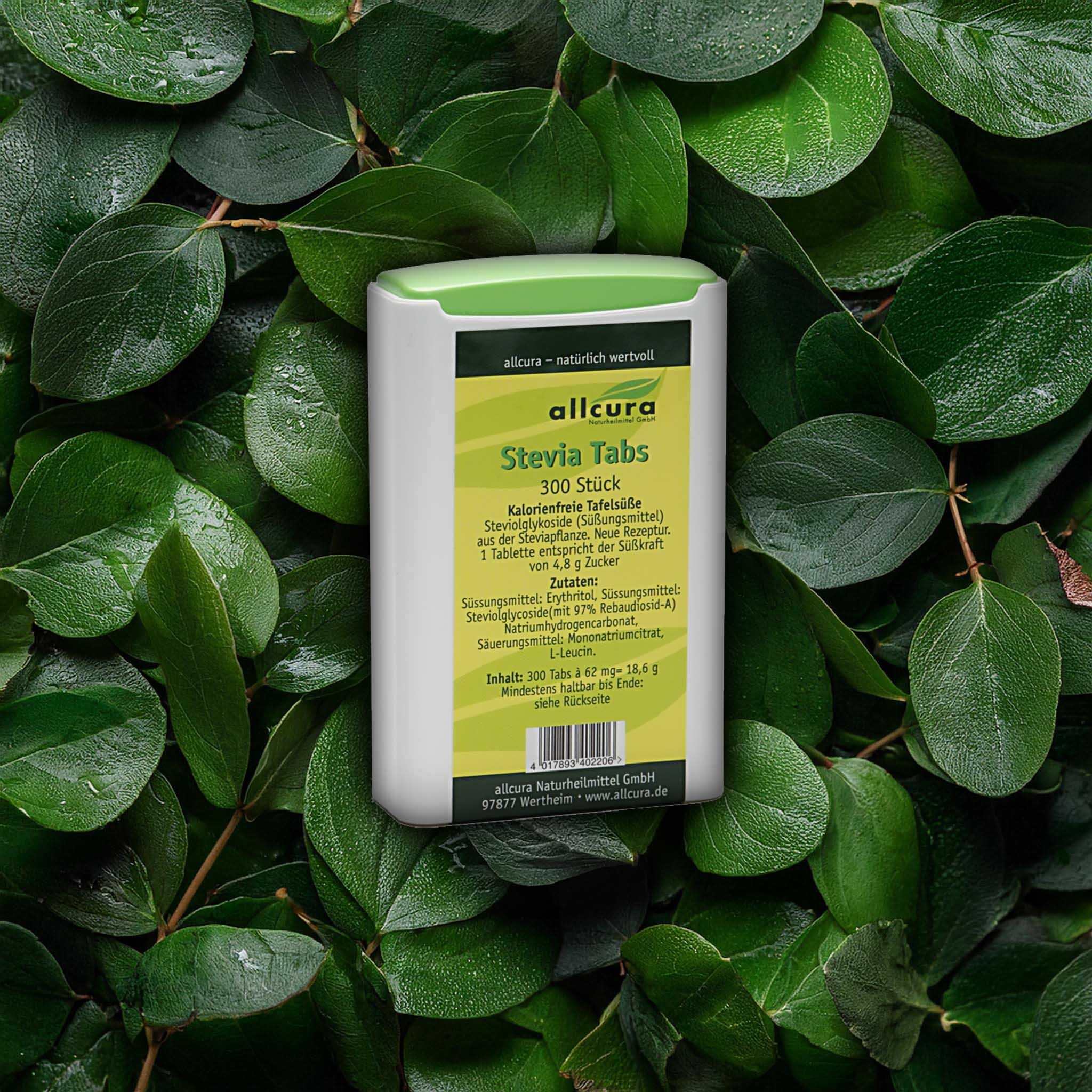 Tabletten-Behältnis mit grünem Deckel, umgeben von Blättern. Aufschrift: Stevia Tabs, 300 Stück. Hersteller: allcura.