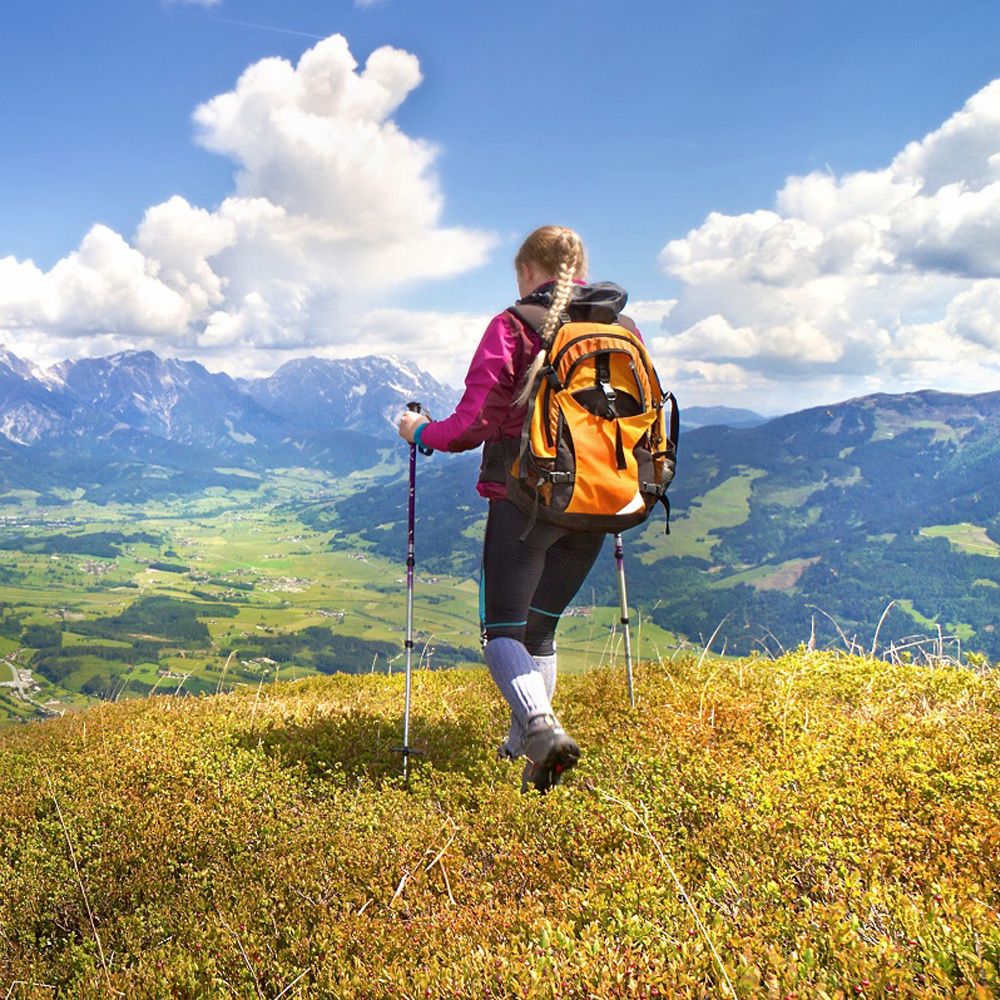 Personne avec un sac à dos randonnée en montagne. Vue sur les montagnes et le ciel bleu avec des nuages.