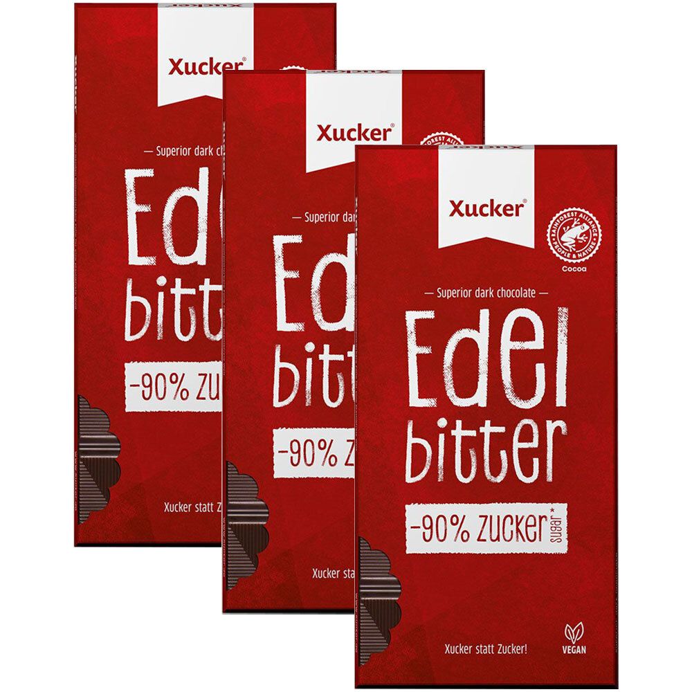 Drei Tafeln Schokolade mit roter Verpackung. Aufschrift: Xucker Edelbitter -90% Zucker. Vegan-Siegel.