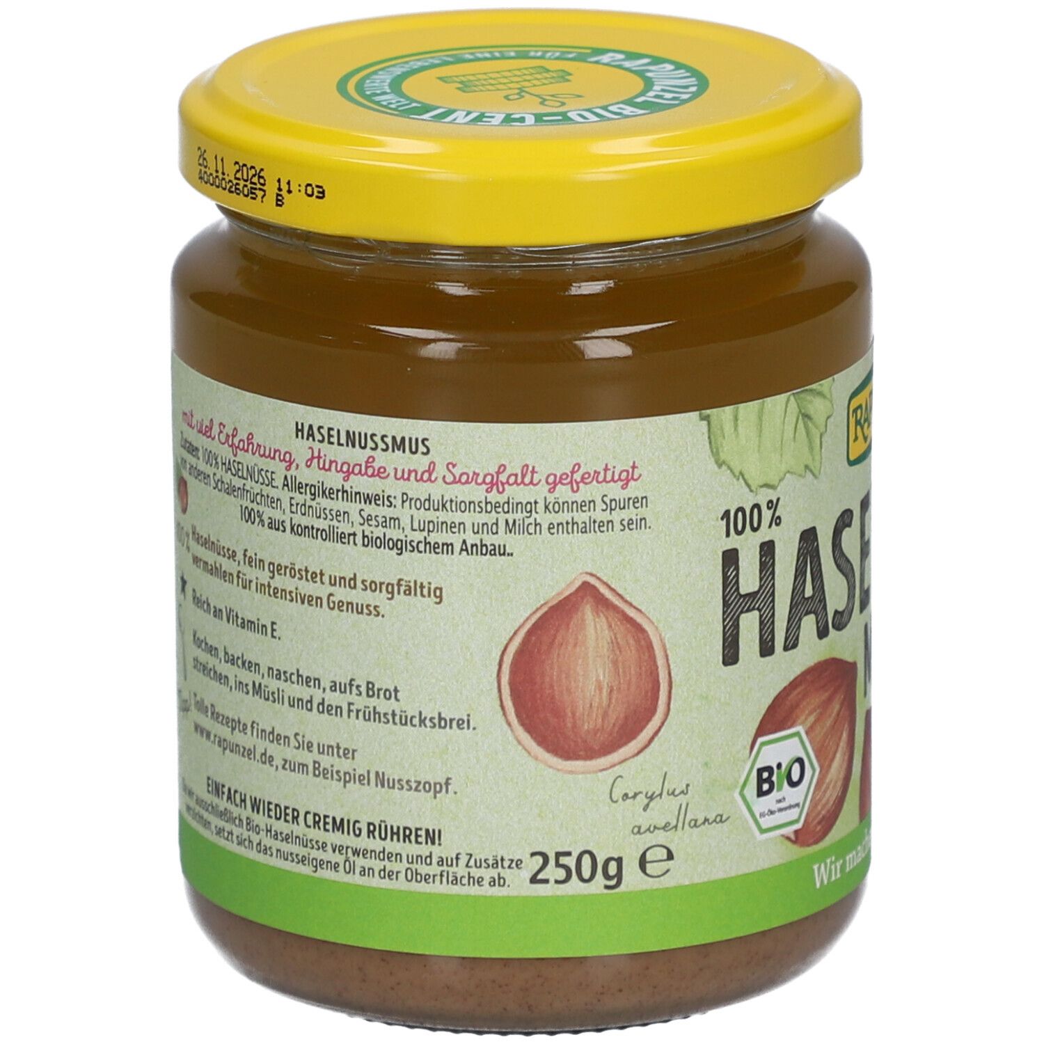 Glas mit Haselnussmus. Gelber Deckel, Etikett mit Text und Zutaten. Aufschrift: 100% Haselnuss, BIO, 250g.