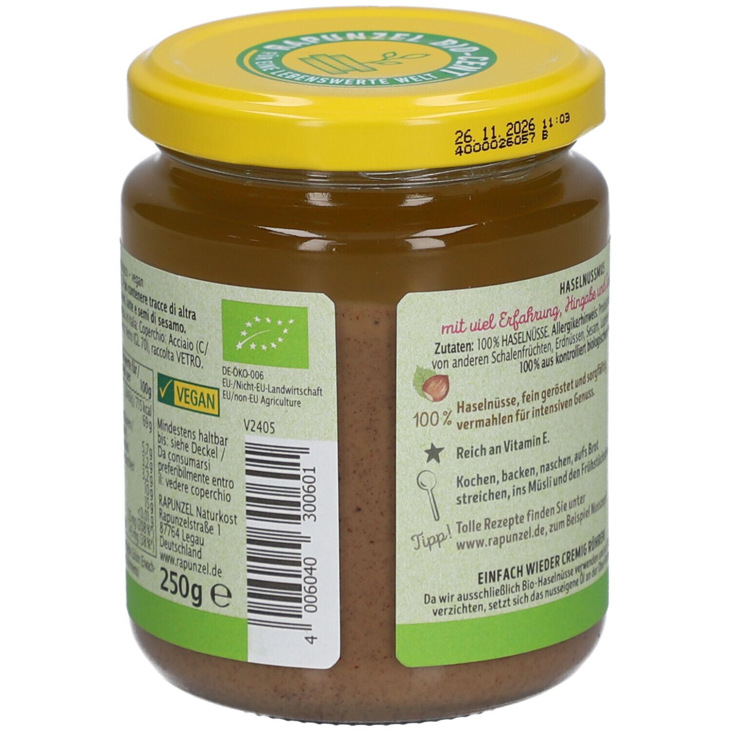 Glas mit Haselnussmus. Gelber Deckel, Etikett mit Text und Nährwertangaben. Aufschrift: Vegan, 250g.