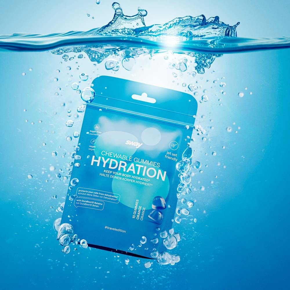 Emballage bleu de "sway CHEWABLE GUMMIES HYDRATION" dans l'eau. L'eau éclabousse. "Jet set friendly". Contient 10 gommes à l'orange.