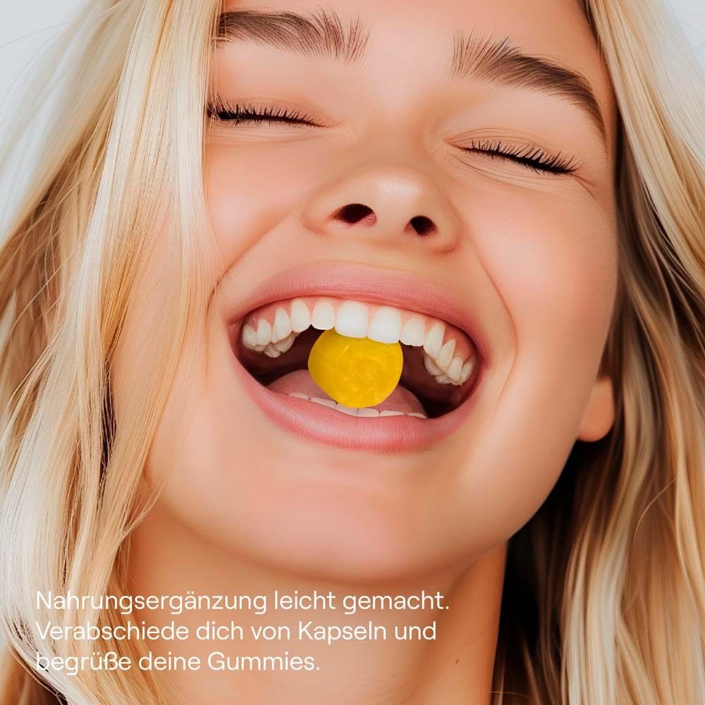 Femme souriante avec un bonbon gélifié jaune dans la bouche. Texte : "Gummies".