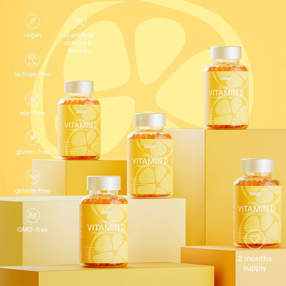 Mehrere Flaschen Vitamin D auf Podesten. Aufschrift: Vitamin D, vegan, laktosefrei, sojafrei, glutenfrei, gelatinefrei, GMO-frei.