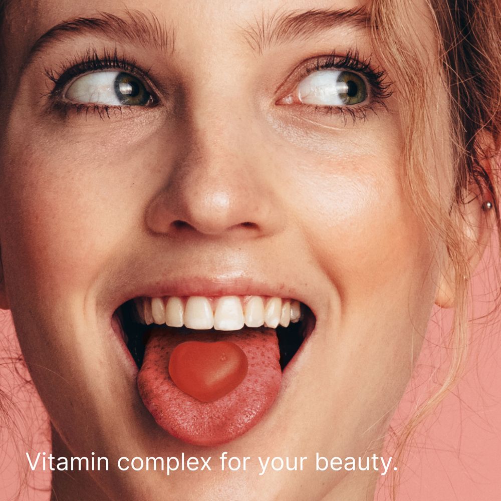 Gros plan sur un visage avec un bonbon gélifié en forme de cœur sur la langue.