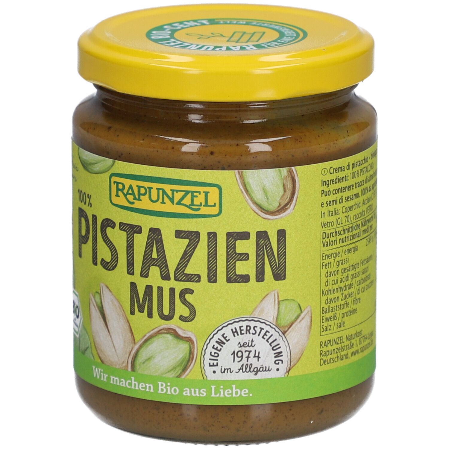 Glas Rapunzel Pistazienmus. Gelber Deckel, grünes Etikett mit Text und Nährwertangaben. Pistazien-Illustrationen.