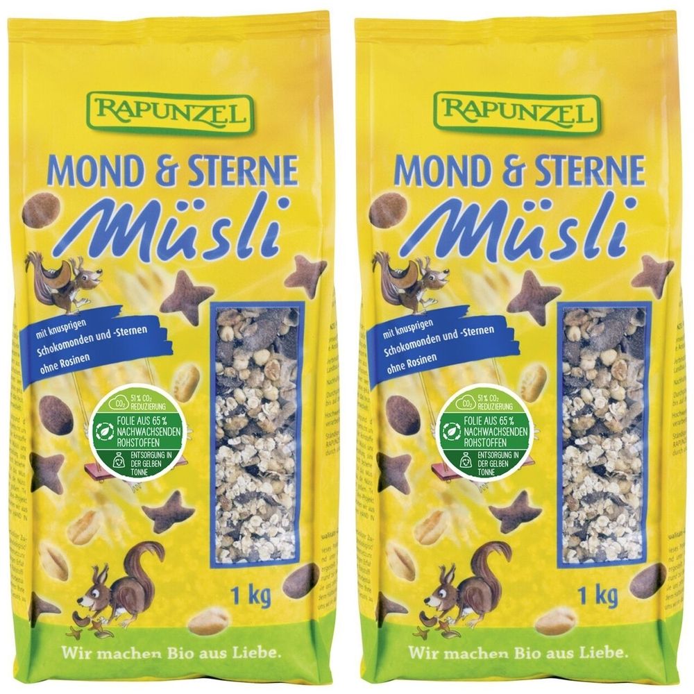 Zwei Beutel Müsli. Gelbe Verpackung mit Produktnamen und Logo. Sichtfenster mit Müsli-Mischung. 1 kg.