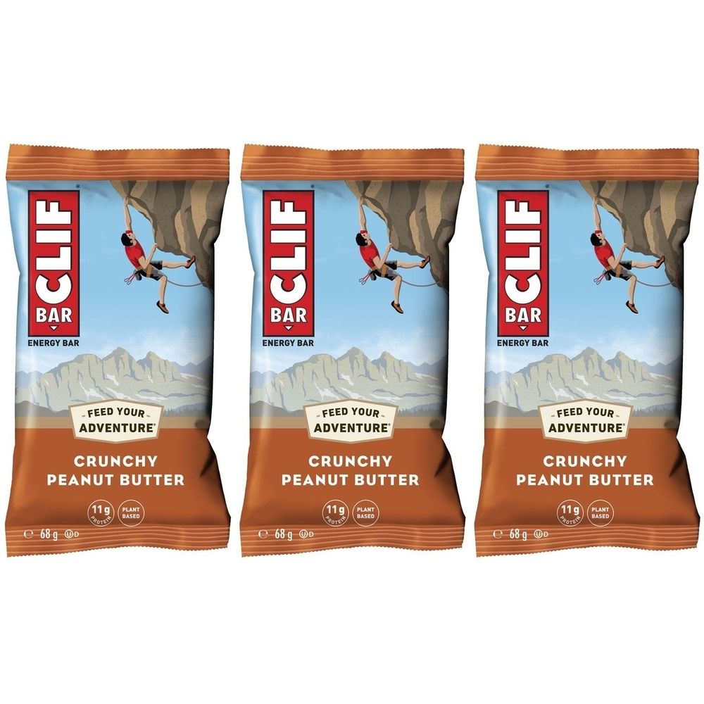 Drei CLIF BAR Energieriegel. Aufdruck: Crunchy Peanut Butter, 11g Protein, Kletterer an Felswand.