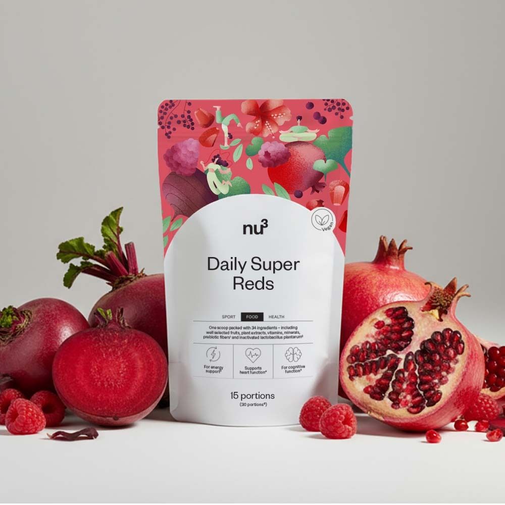 Emballage du produit « nu3 Daily Super Reds » avec des fruits rouges. Betteraves, framboises et grenades entourent le produit.