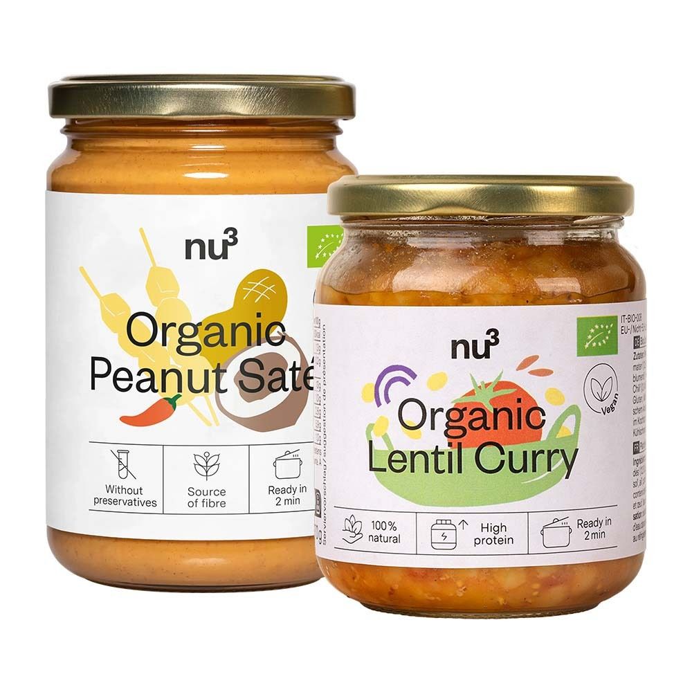 Deux pots de "nu3 Organic Peanut Saté" et "Organic Lentil Curry". Pots avec couvercles dorés et étiquettes blanches.