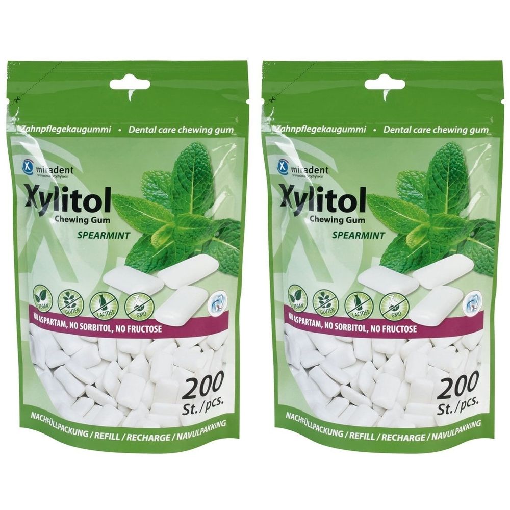 Deux sachets de chewing-gum. Inscription : Xylitol, Spearmint, 200 pièces. Emballage vert et blanc avec illustration de menthe.