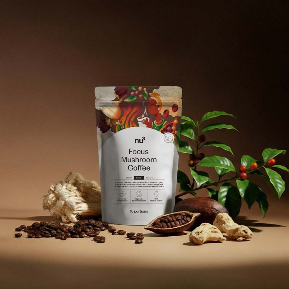 Beutel nu3 Focus Mushroom Coffee mit Kaffeebohnen, Kakaobohnen und Pilzen auf braunem Untergrund.