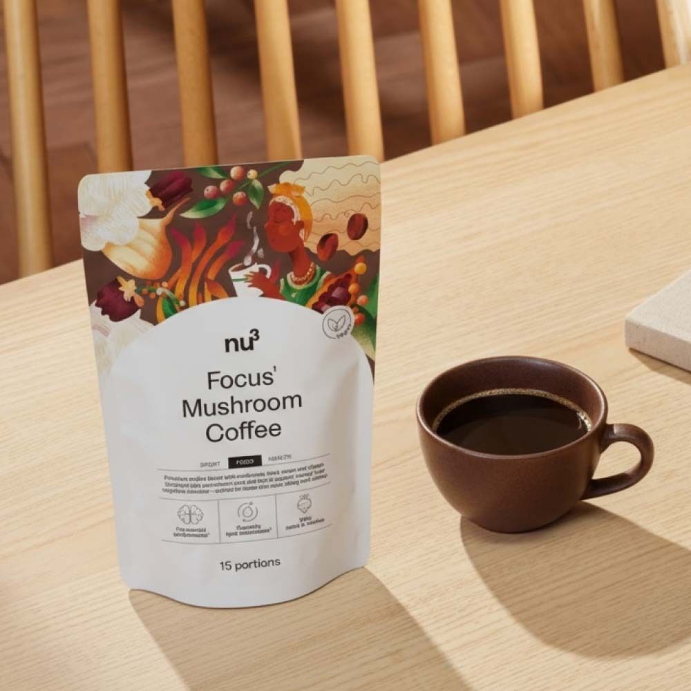 Tasse Kaffee neben Beutel nu3 Focus Mushroom Coffee. Auf Tisch platziert.