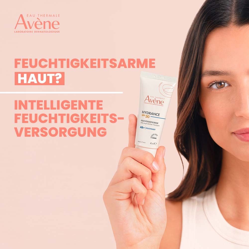 Femme tenant Avène Hydrance crème hydratante SPF 30. Texte : Peau déshydratée ? Hydratation intelligente. Tube blanc avec texte rouge.