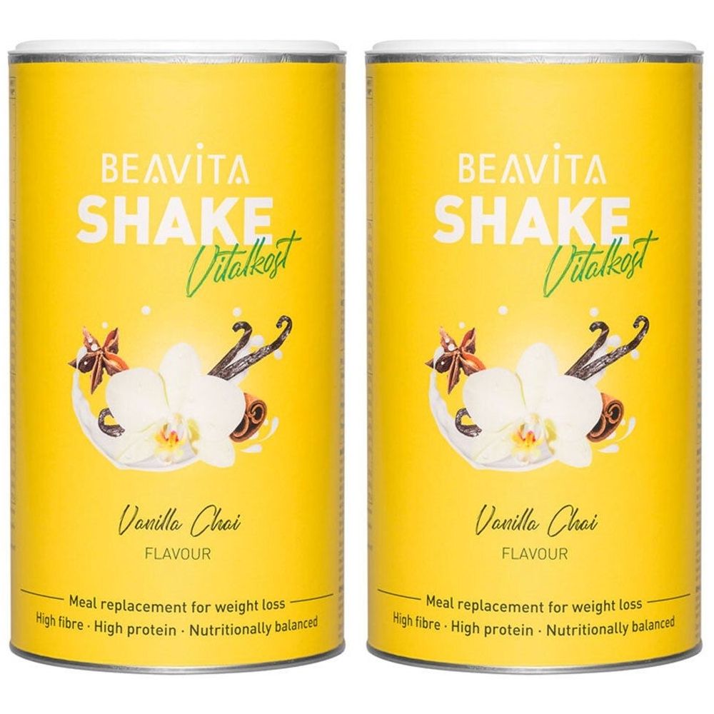Zwei gelbe Dosen mit Produktaufdruck. Schriftzug: BEAVITA SHAKE Vitalkost. Geschmack: Vanilla Chai. Mit floralem Dekor.