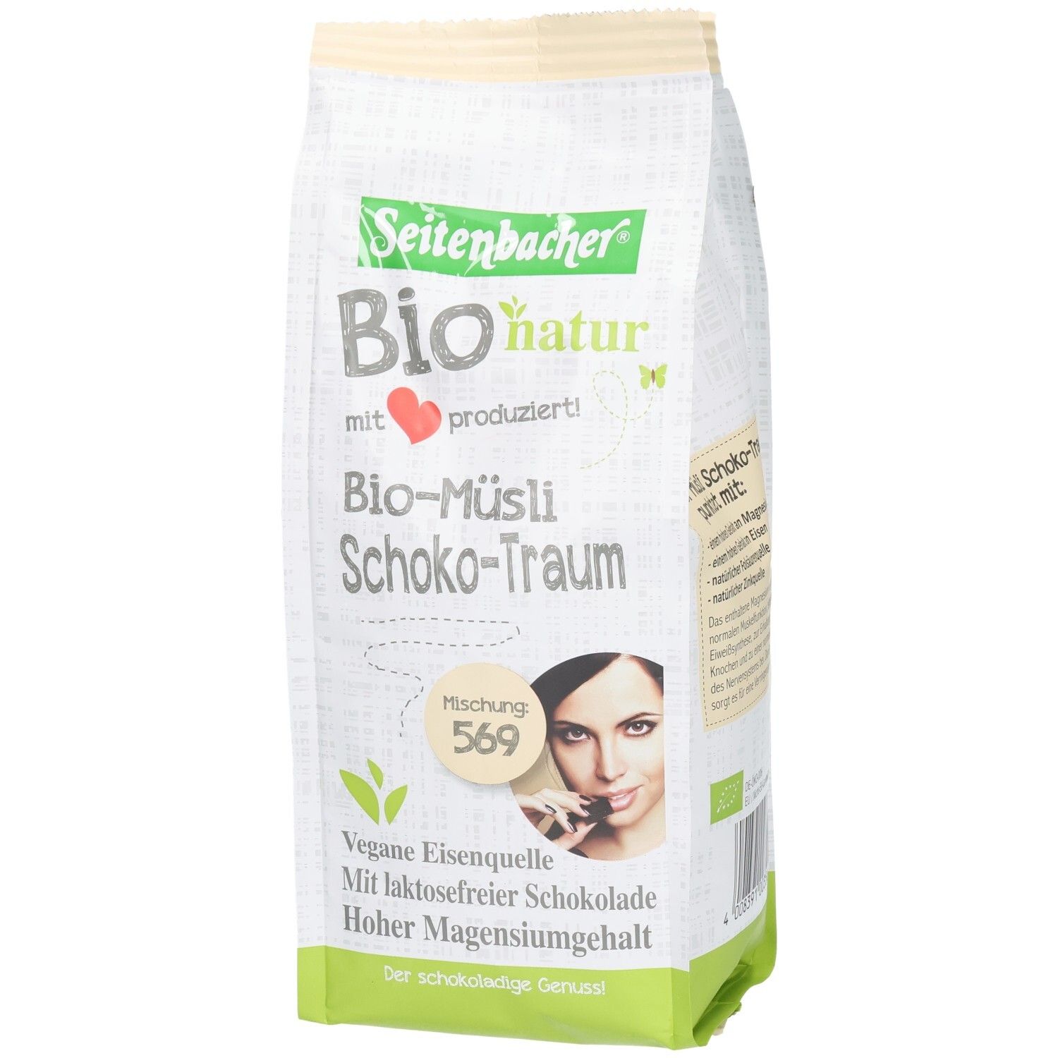 Verpackung von Seitenbacher Bio-Müsli Schoko-Traum. Aufdrucke: Bio-natur, vegane Eisenquelle, laktosefreie Schokolade, hoher Magnesiumgehalt. Frau mit Schokoriegel.