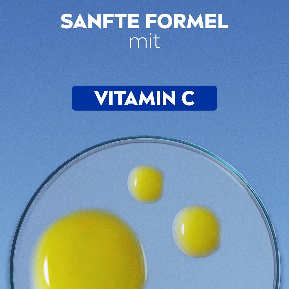 Gelbe Flüssigkeitstropfen. Vitamin C. Auf blauem Hintergrund.