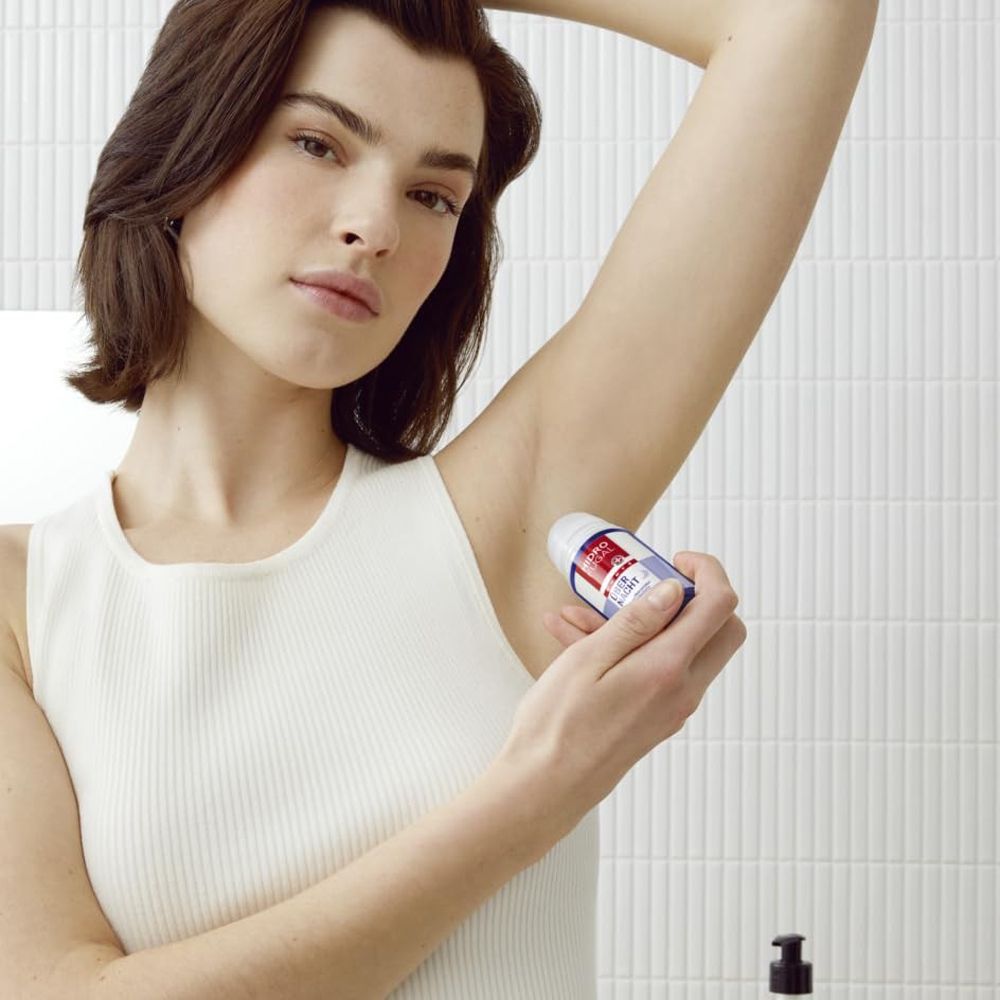 Une femme applique le déodorant roll-on Hidrofugal Forte Über Nacht sous son bras.