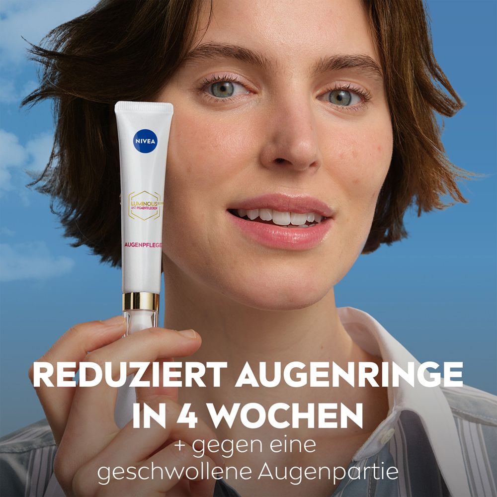 Femme tenant un tube NIVEA LUMINOUS630® Soin Yeux devant un ciel bleu. Texte : Réduit les cernes en 4 semaines.