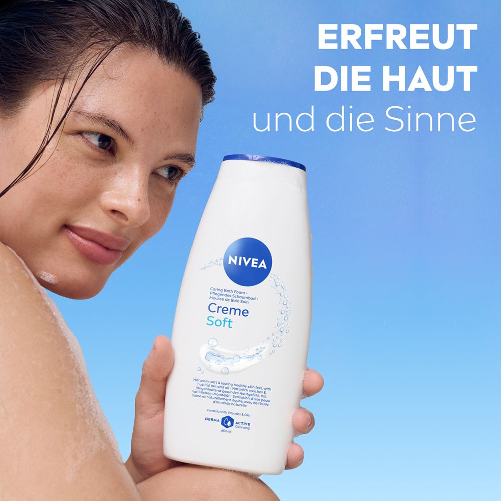 Weiße Nivea Creme Soft Body Wash Flasche mit blauem Deckel, gehalten von einer Frau.