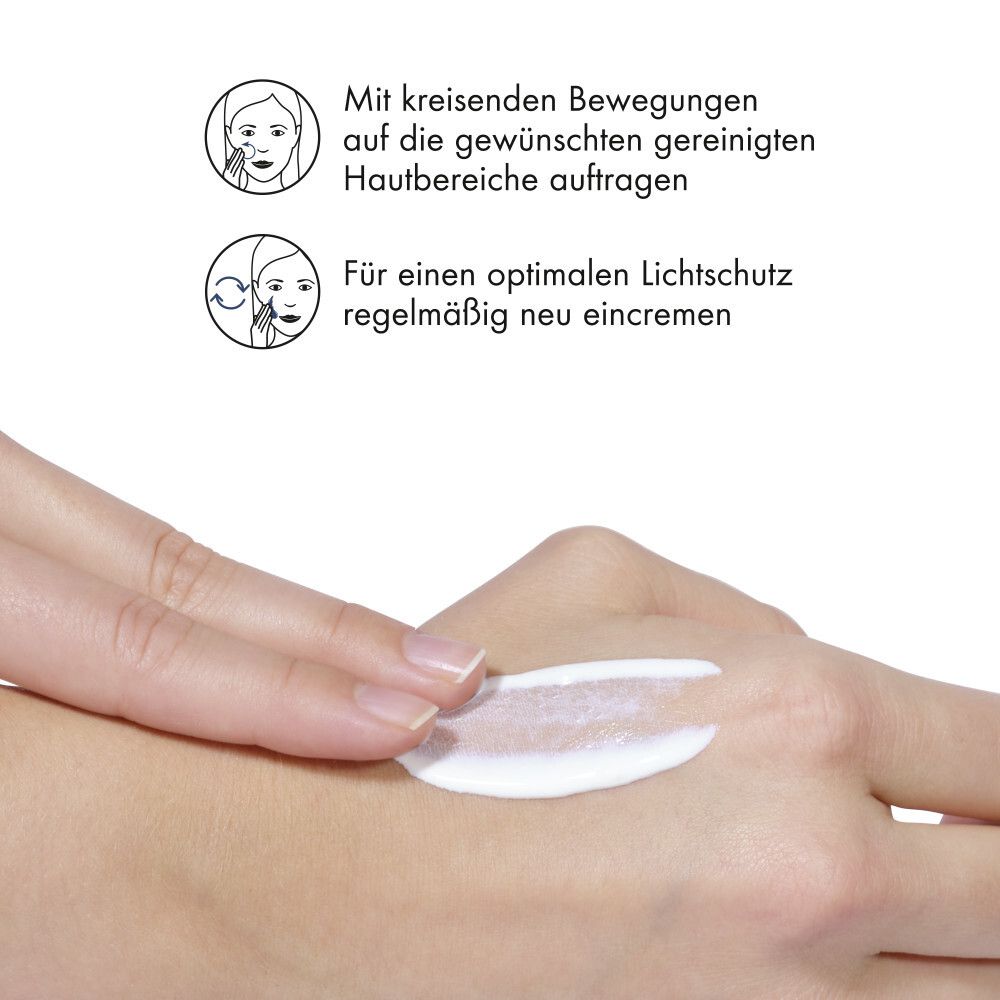 Hand mit Sonnenfluid. Anweisungen: Mit kreisenden Bewegungen auftragen, regelmäßig neu eincremen.