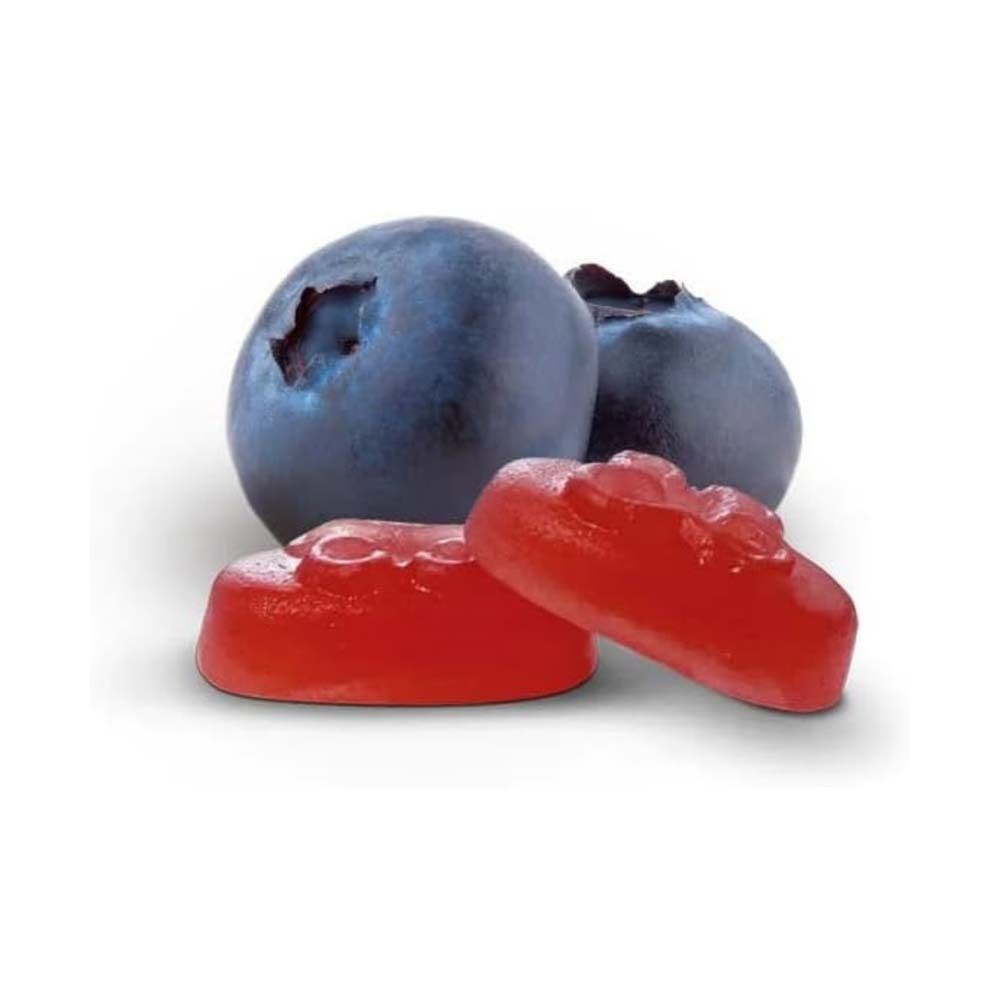 Blaubeeren und rote Pastillen. Zwei Blaubeeren, zwei rote Pastillen in Tropfenform.