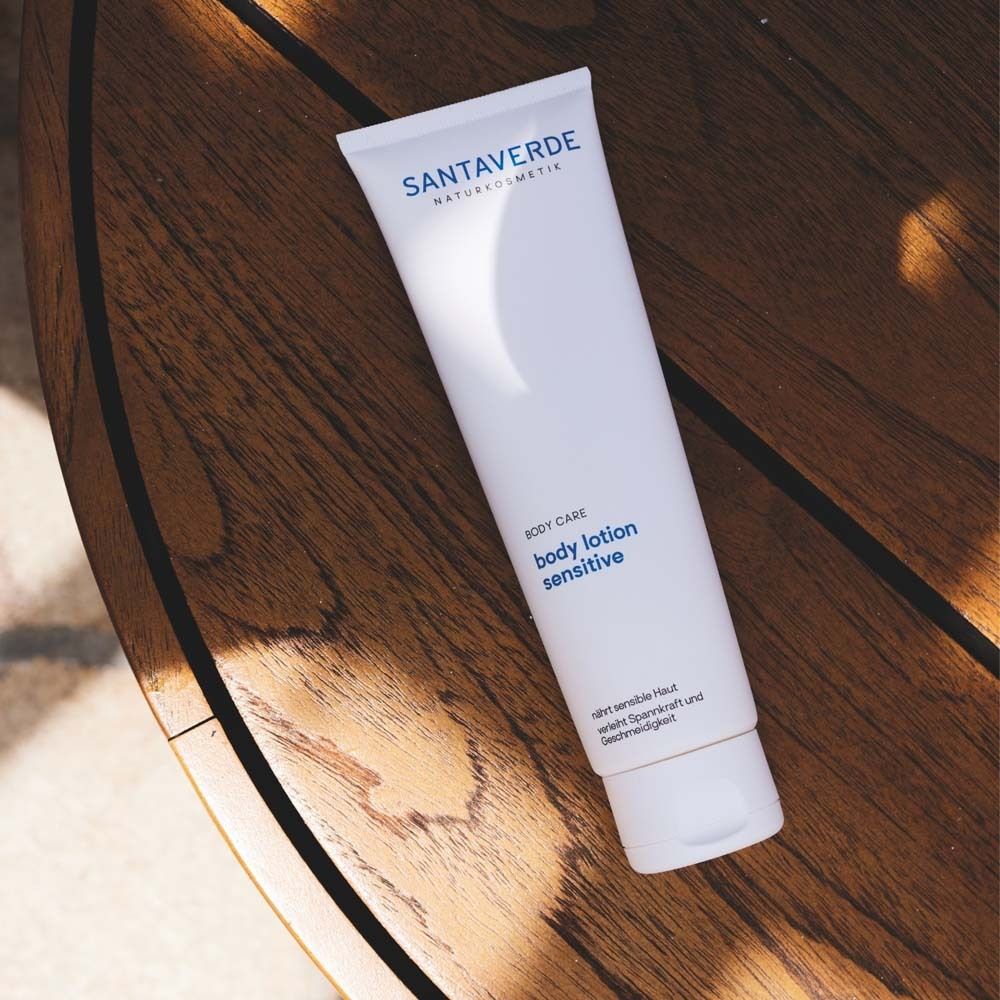 Tube blanc SANTAVERDE body lotion sensitive sur surface en bois. Produit pour peaux sensibles.