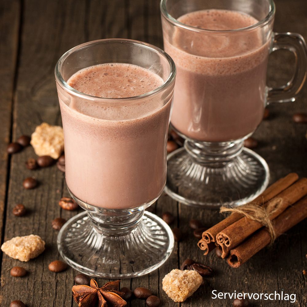 Deux verres de boisson au chocolat avec bâtons de cannelle et badiane. Exemple de service.