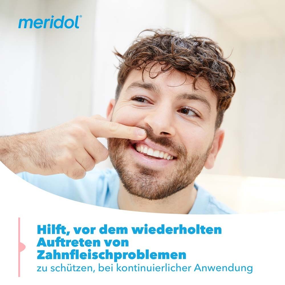 Mann zeigt auf sein Zahnfleisch. Text: Hilft, vor dem wiederholten Auftreten von Zahnfleischproblemen zu schützen.