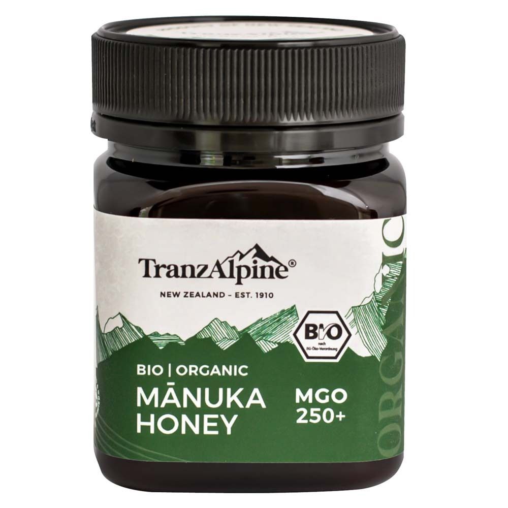 Pot en verre brun avec couvercle noir. Étiquette avec "TranzAlpine", "Manuka Honey", "MGO 250+" et label bio.