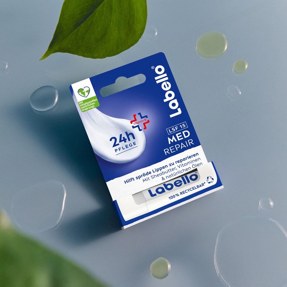 Baume à lèvres Labello Med Repair en emballage sur fond bleu avec gouttes d'eau.