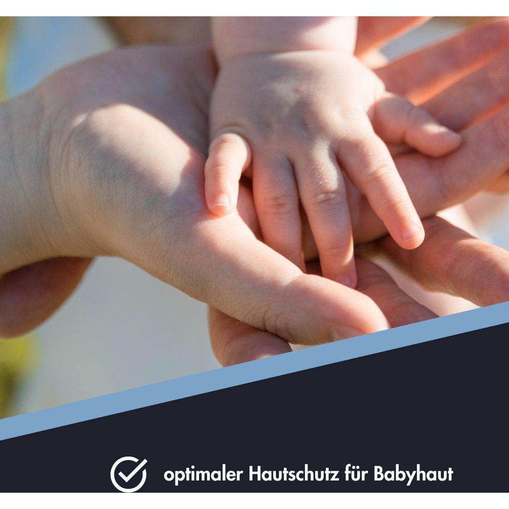 Mains d'un adulte et d'un bébé se touchant. Protection optimale de la peau pour bébé.