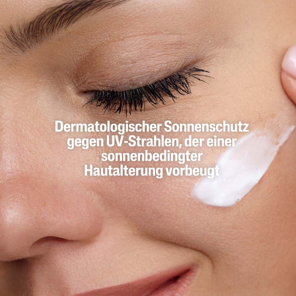 Gros plan sur visage avec crème. Texte: Protection solaire dermatologique.
