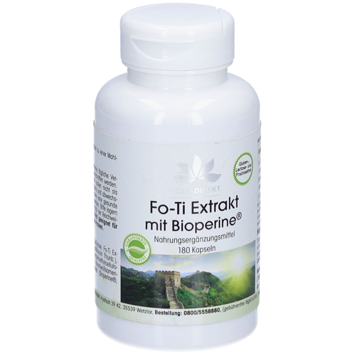Flacon blanc de Fo-Ti Extrakt mit Bioperine® Kapseln. Inscription: Complément alimentaire, 180 gélules. Paysage en arrière-plan.