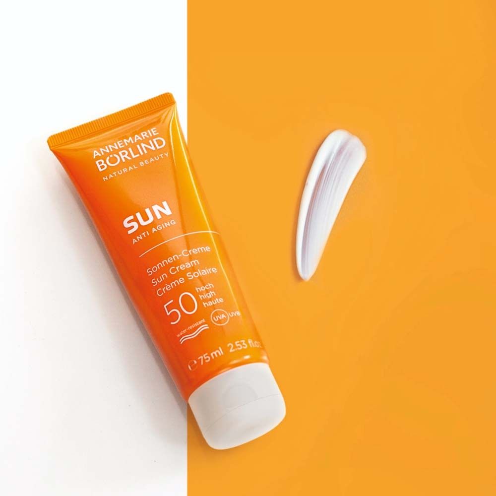 Tube orange de crème solaire et goutte de crème. Texte: ANNEMARIE BÖRLIND SUN Anti-Aging, SPF 50. 75 ml.