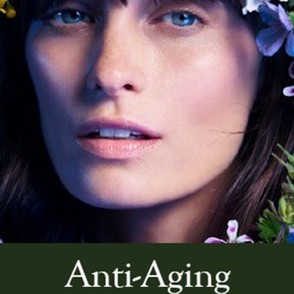 Visage de femme avec des fleurs. Texte: Anti-Âge.